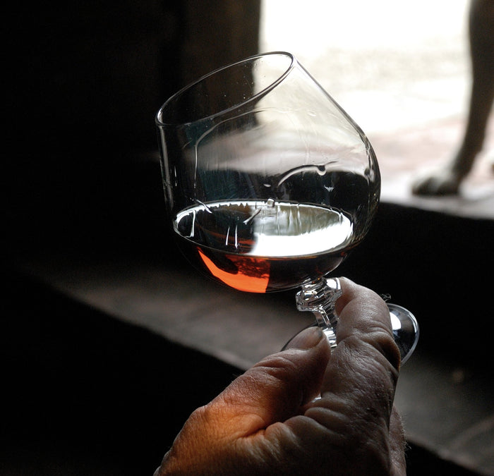 Brandy in a glass. Cognac or Armagnac from france being held in a glass by a hand. Aged or vintage brandy